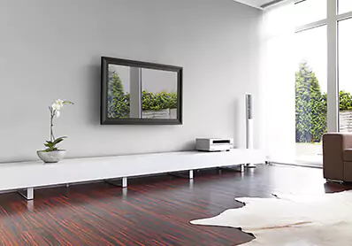 Framed smart mirror TV mounted on a white wall above a full-length sideboard in a living room.
